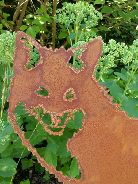 Edelrost Fuchs Fido sitzend auf Spießen